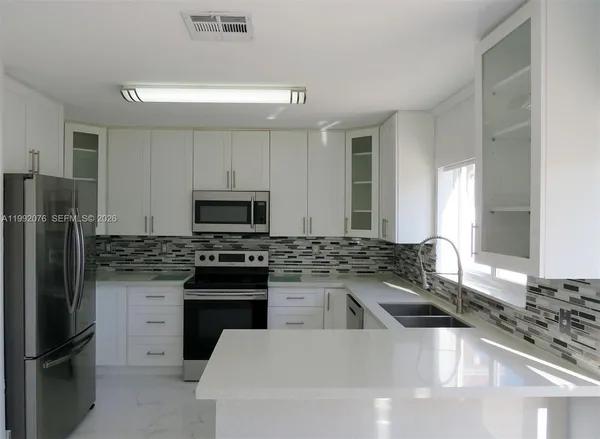 a kitchen with a sink stove and refrigerator