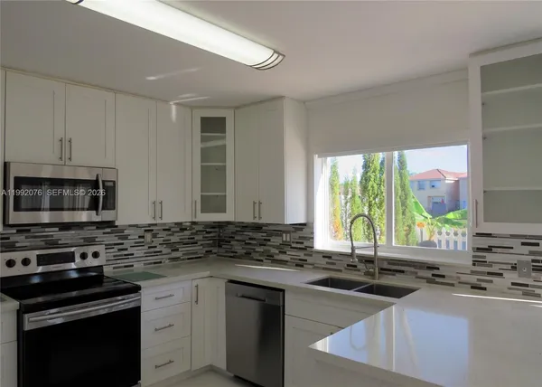 a kitchen with stainless steel appliances a stove sink and cabinets