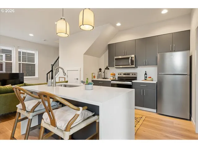 a kitchen with a table chairs refrigerator and microwave