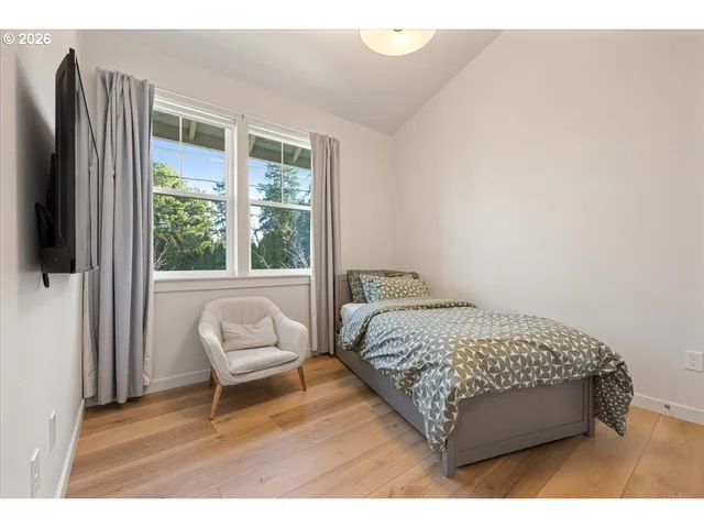 a bedroom with a bed chair and a window