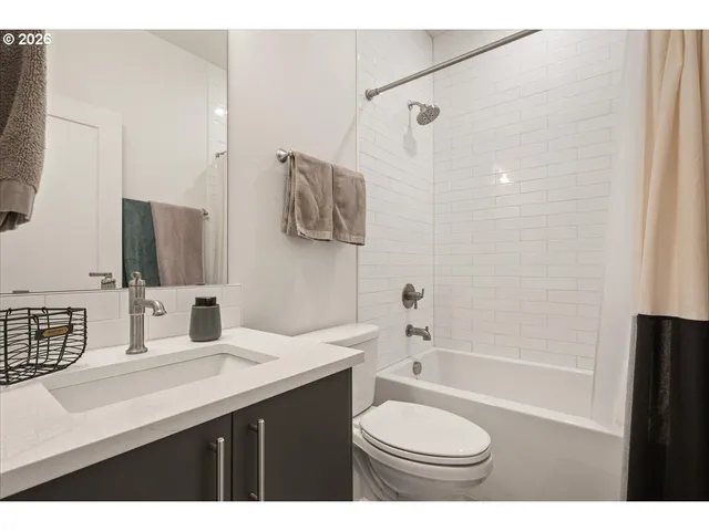 a bathroom with a sink a toilet a mirror and shower