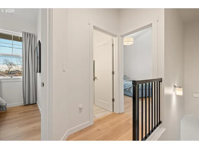 a view of a hallway with wooden floor and windows
