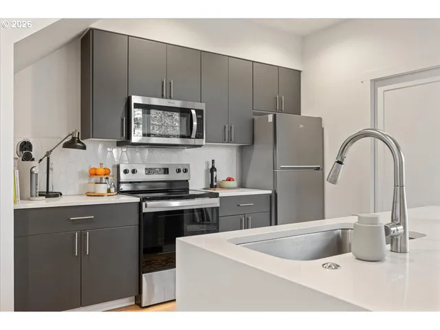 a kitchen with stainless steel appliances granite countertop a sink stove and refrigerator