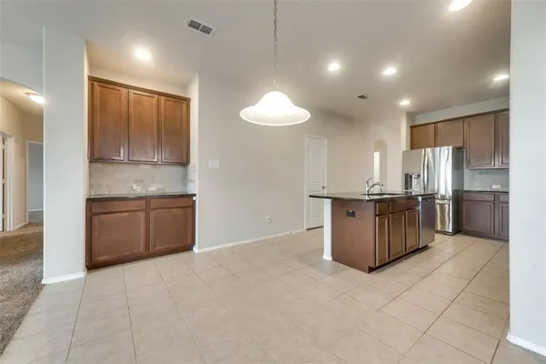 a kitchen with stainless steel appliances granite countertop a stove a sink and a refrigerator