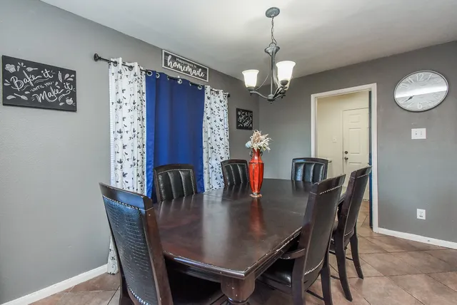 a dining room with furniture a chandelier and window
