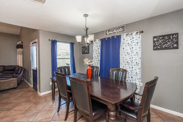 a view of a dining room and livingroom with furniture wooden floor a chandelier