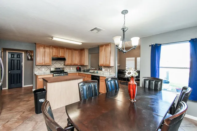 a kitchen with a stove a sink a microwave a refrigerator and cabinets