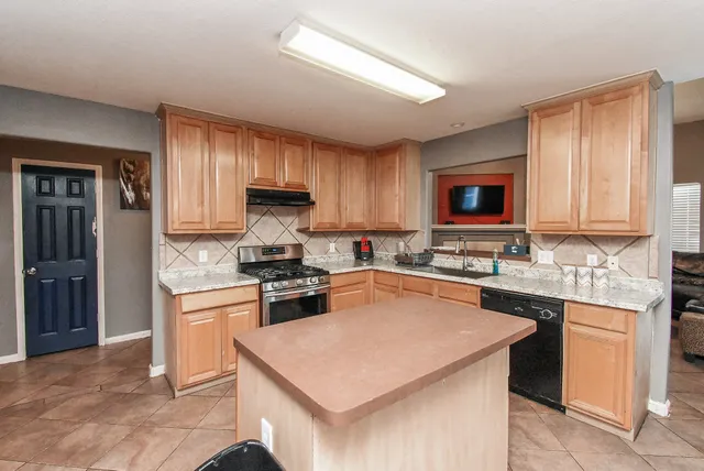 a kitchen that has a table chairs and a refrigerator