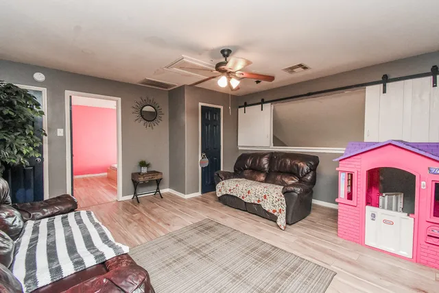 a couch sitting in a room next to a window and a chandelier