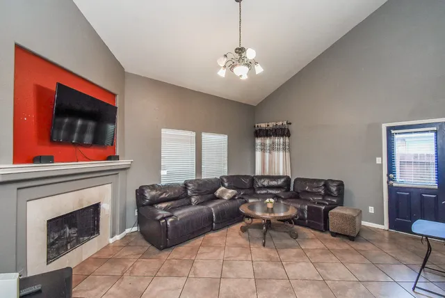 a living room with furniture a fireplace and a flat screen tv