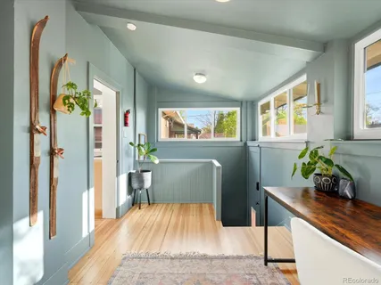 a hallway with a dining table wooden floor and a window