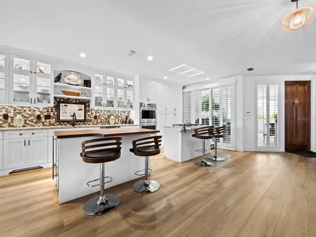 a view of a kitchen with kitchen island and stainless steel appliances