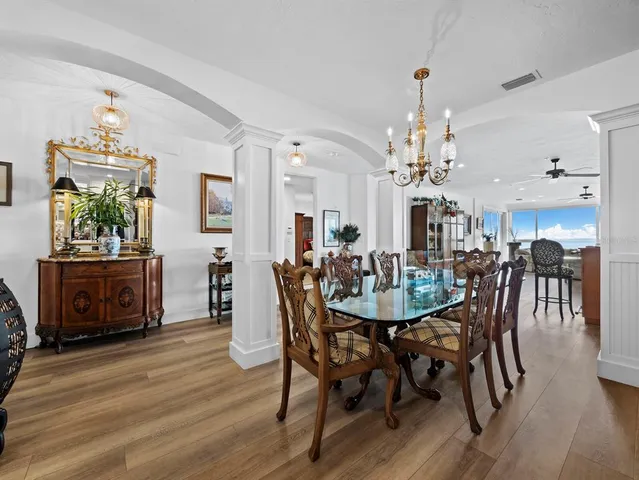 a dining room with furniture a chandelier and wooden floor
