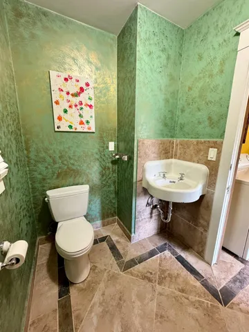 a bathroom with a sink a toilet and a mirror