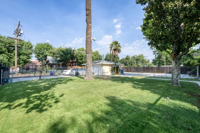 a front view of house with yard outdoor seating and covered with trees