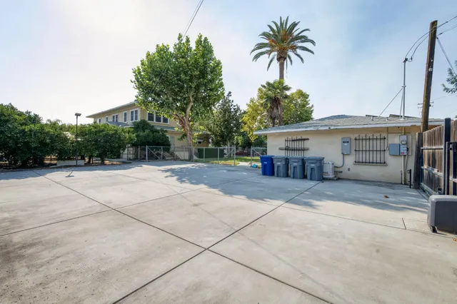 a backyard of a house with a tree and fence