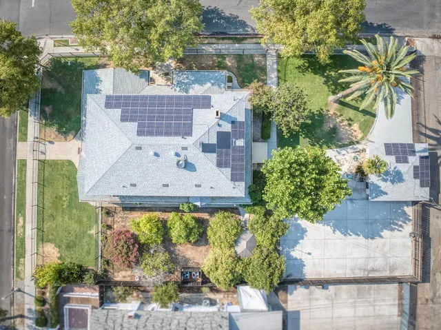an aerial view of a house with a yard and large trees