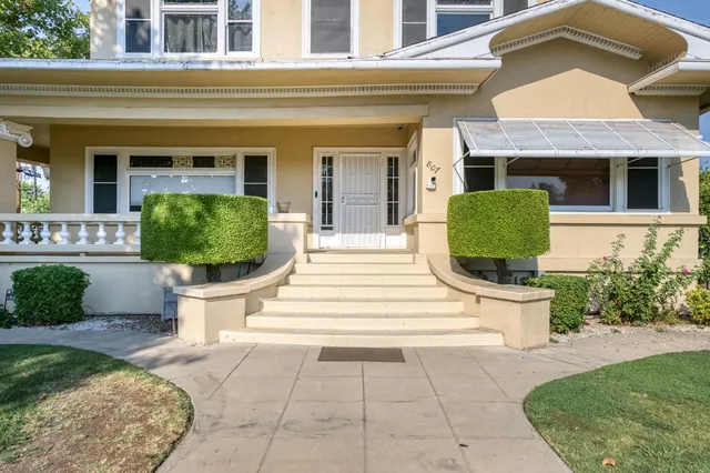 a front view of a house with a garden and plants