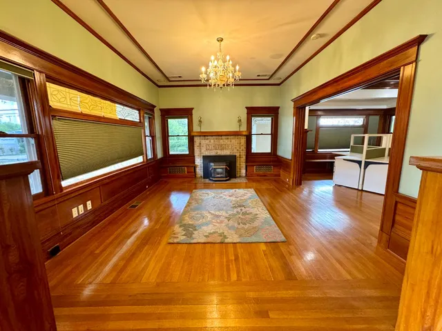 a living room with fireplace furniture flat screen tv and wooden floor