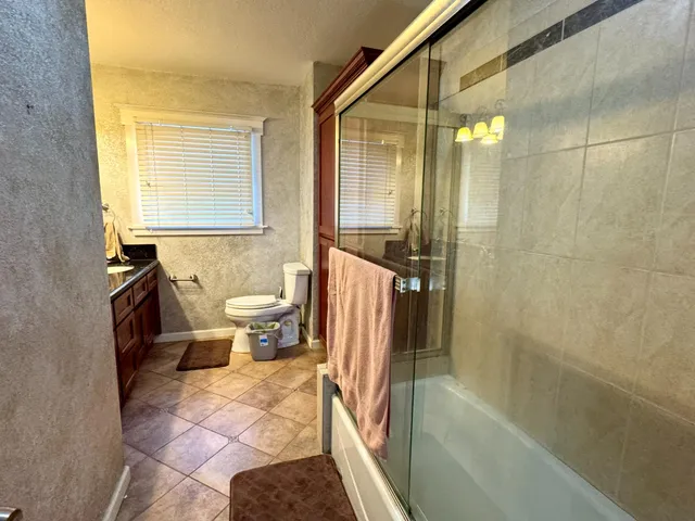 a bathroom with a sink a toilet a mirror and shower