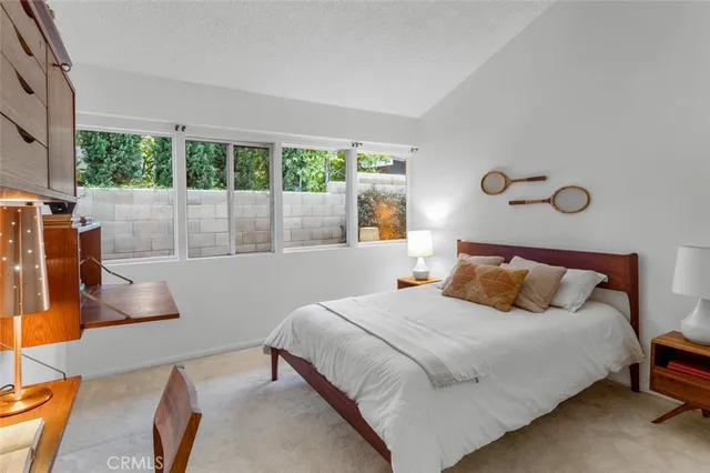 a bedroom with a bed and a large window