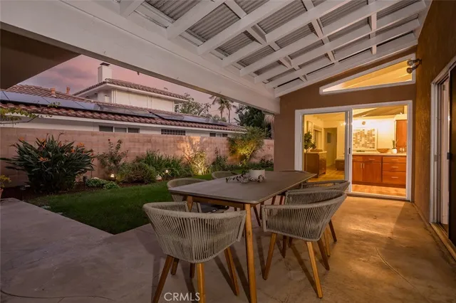 a view of a patio with couches table and chairs and potted plants