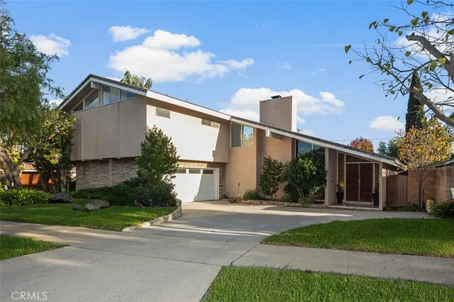 a front view of a house with a yard and trees