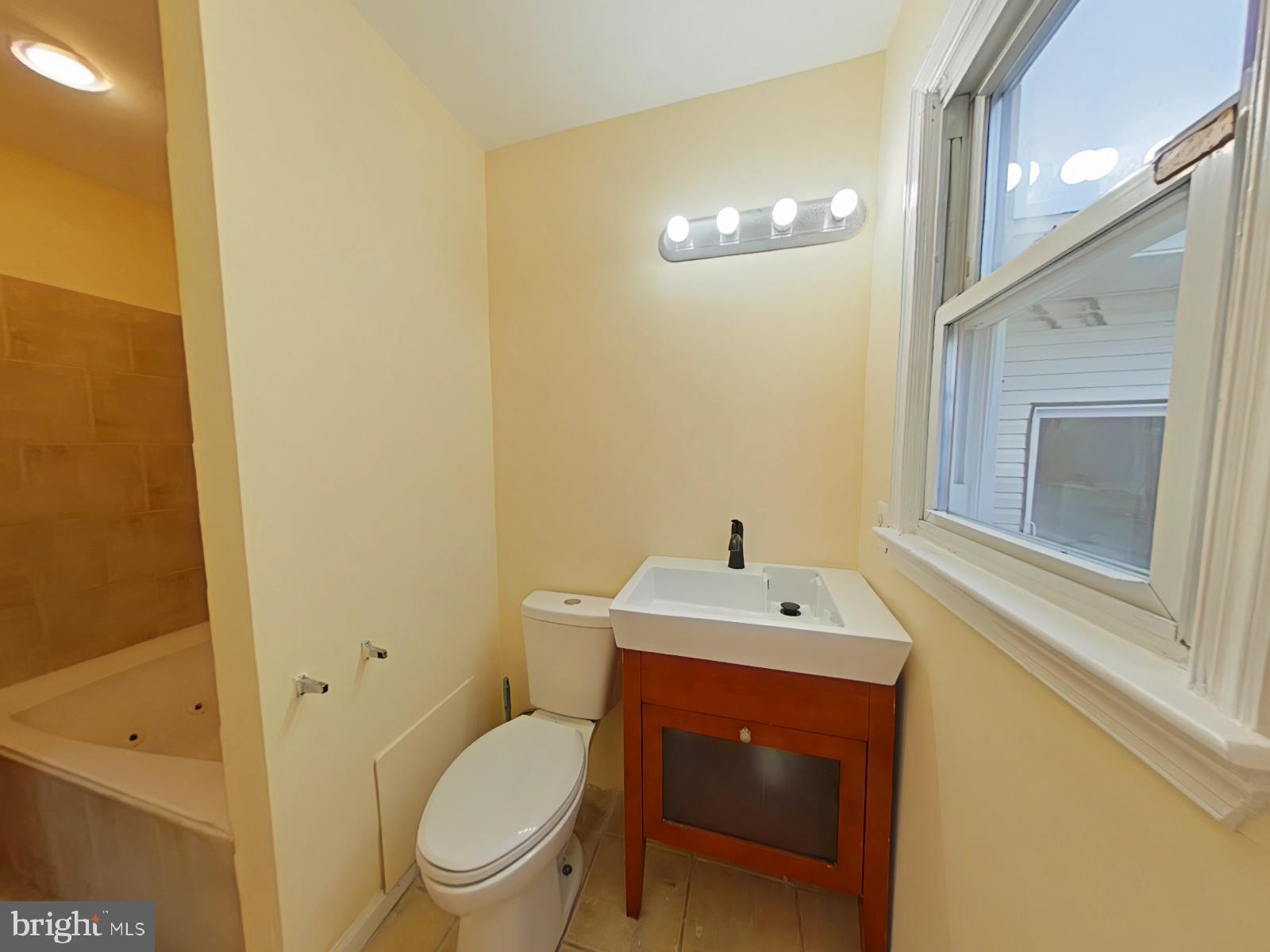 8611 Westphalia Road Upper Marlboro, MD 20772 - Photo 10 of 26 a bathroom with a toilet a sink and mirror