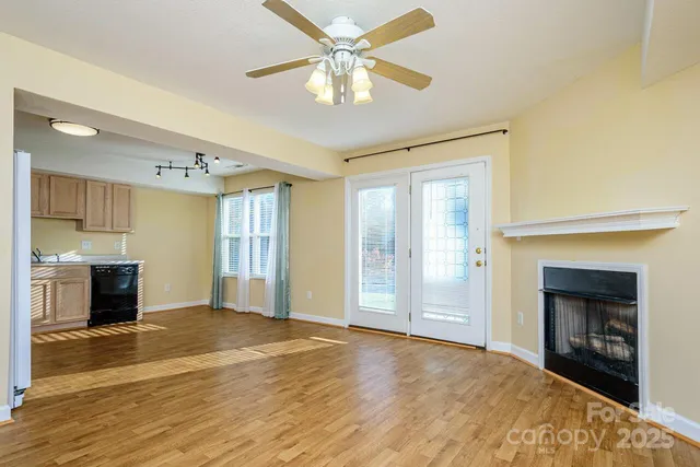 a view of an empty room with a fireplace and a window