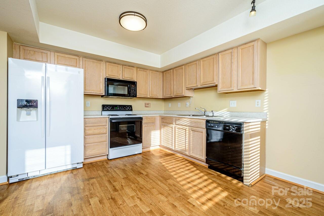 606 Olde Covington Way Arden, NC 28704 - Photo 18 of 38 a kitchen with granite countertop a stove top oven a sink and a refrigerator