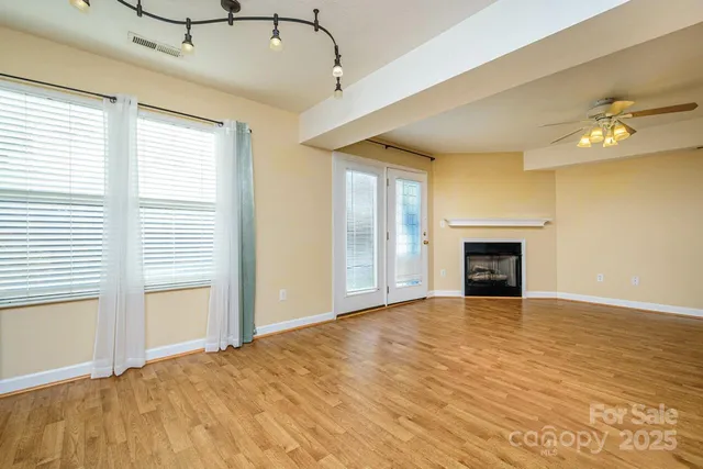 a view of an empty room with a fireplace and a window