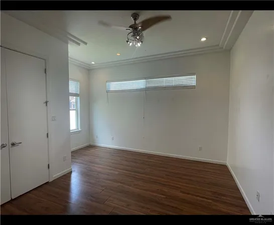 a view of an empty room with wooden floor