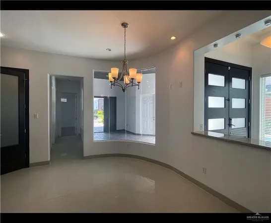 a view of a room with a chandelier fan and windows