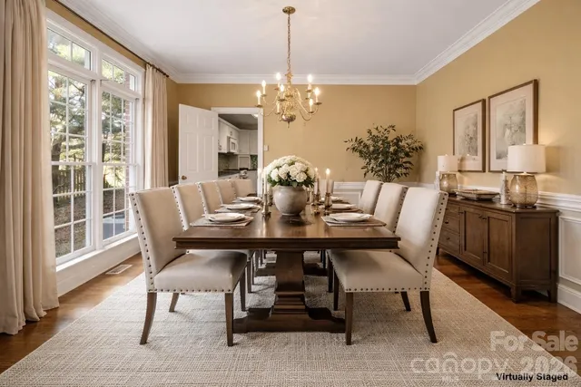 a kitchen with stainless steel appliances granite countertop a stove a sink dishwasher and white cabinets with wooden floor