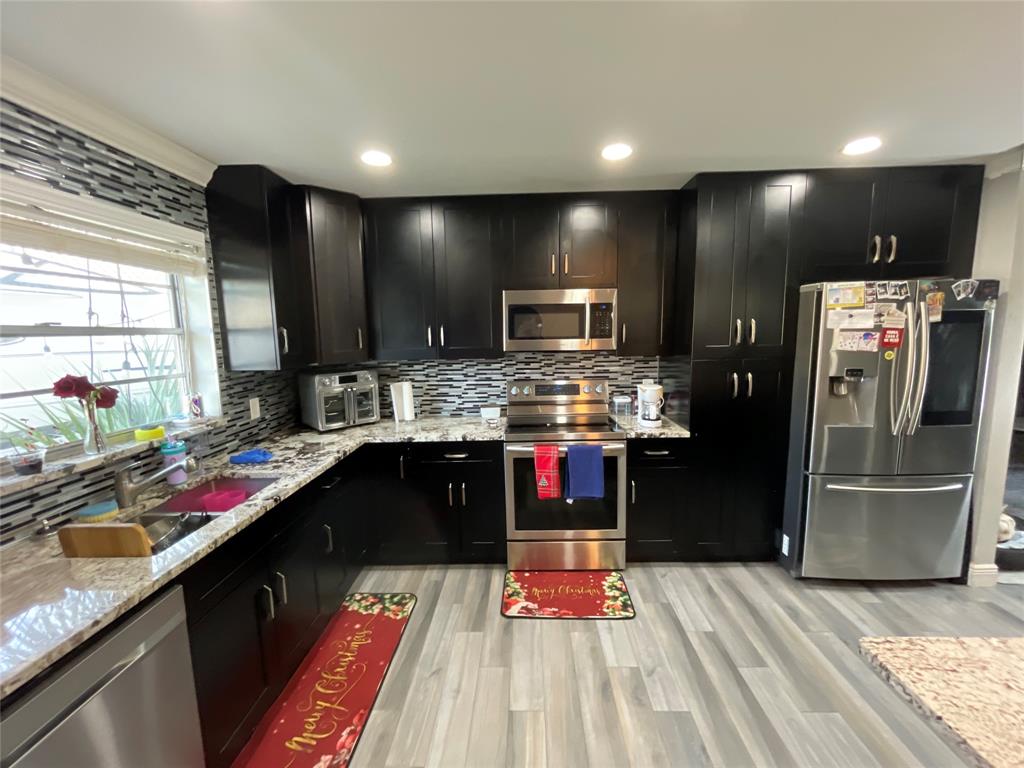 9020 Pine Springs Drive Boca Raton, FL 33428 - Photo 17 of 21 a kitchen with stainless steel appliances kitchen island granite countertop a refrigerator stove and sink