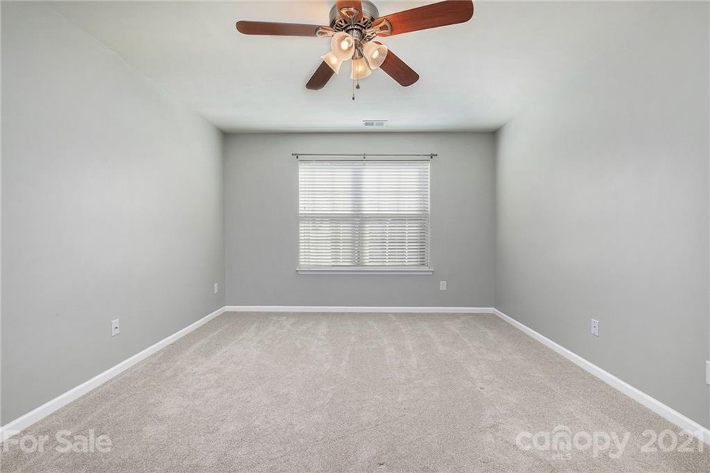 17107 Hampton Trace Road Huntersville, NC 28078 - Photo 14 of 18 an empty room with chandelier fan and windows