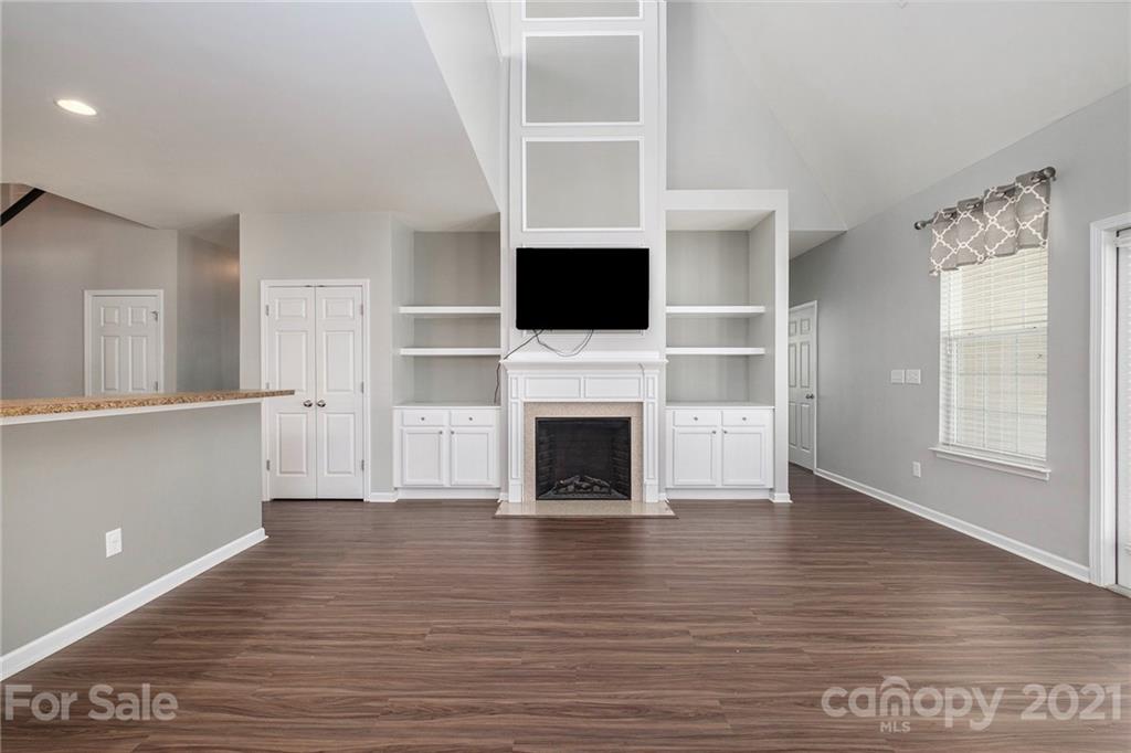 17107 Hampton Trace Road Huntersville, NC 28078 - Photo 3 of 18 a living room with a fireplace and a flat screen tv