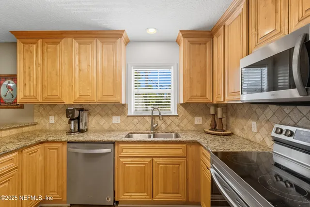 a kitchen with stainless steel appliances granite countertop a sink stove and cabinets