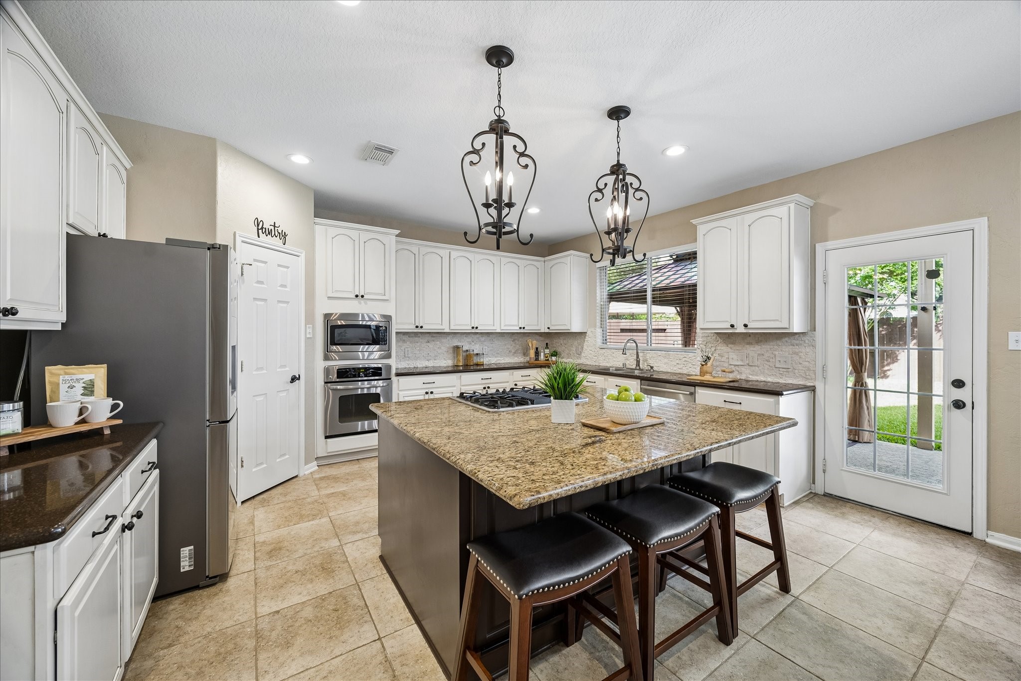 9122 Memorial Valley Drive Spring, TX 77379 - Photo 11 of 35 a kitchen with granite countertop kitchen island stainless steel appliances a table chairs sink refrigerator and microwave