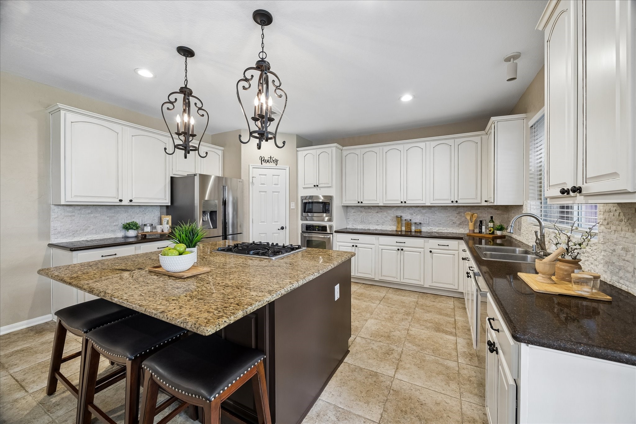 9122 Memorial Valley Drive Spring, TX 77379 - Photo 14 of 35 a kitchen with granite countertop kitchen island stainless steel appliances a sink stove and refrigerator
