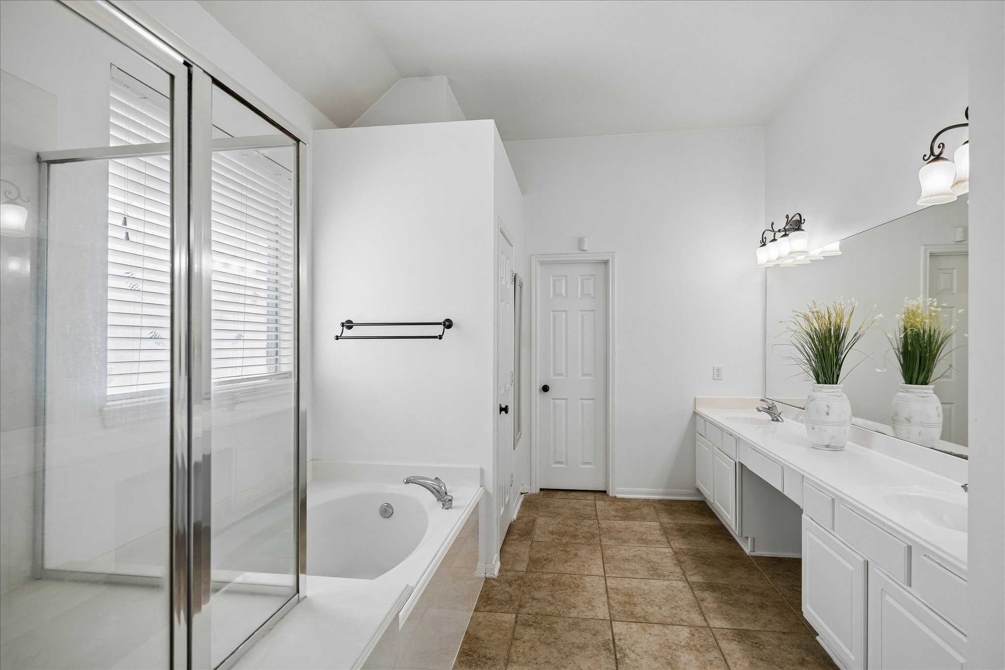 9122 Memorial Valley Drive Spring, TX 77379 - Photo 17 of 35 a bathroom with a double vanity sink a large mirror a shower and bathtub
