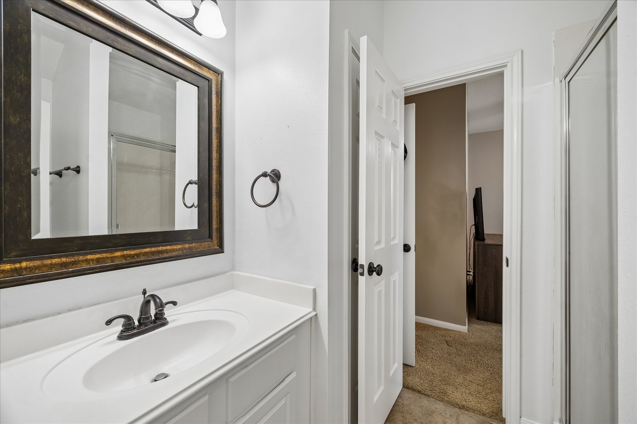 9122 Memorial Valley Drive Spring, TX 77379 - Photo 20 of 35 a bathroom with a sink a mirror and a shower