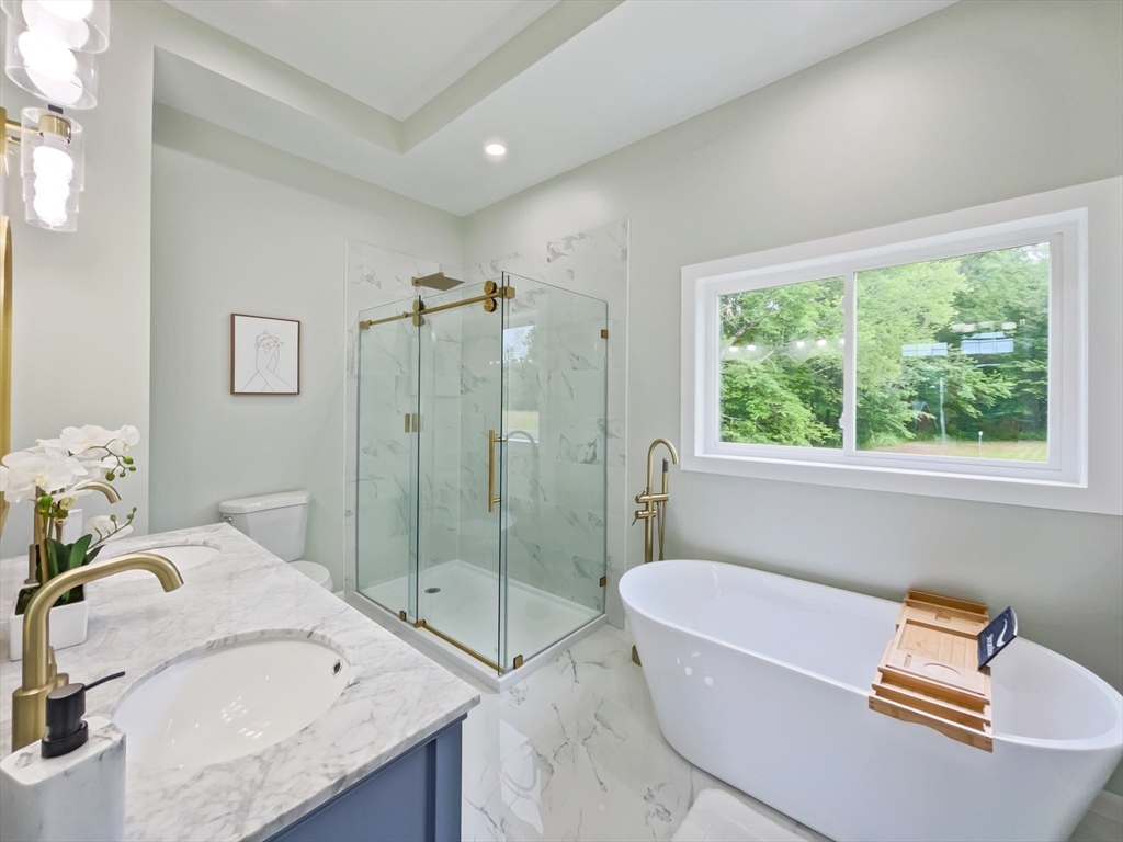101 N Road Westfield, MA 01085 - Photo 28 of 40 a bathroom with a granite countertop tub a sink a mirror and a shower