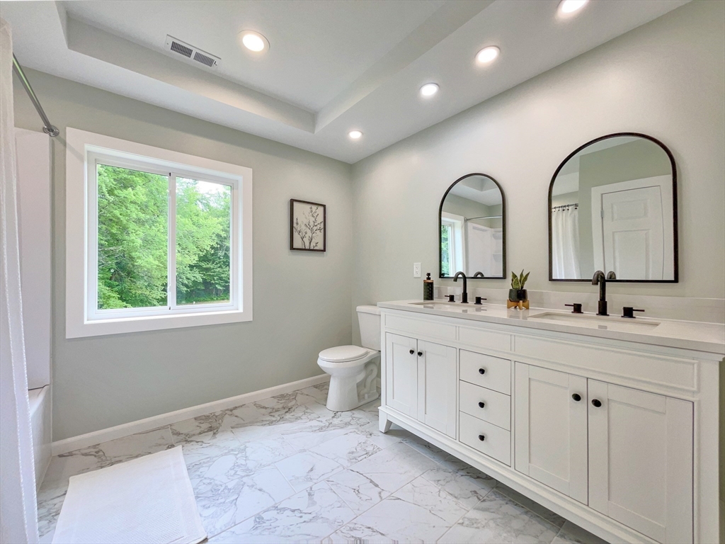 101 N Road Westfield, MA 01085 - Photo 30 of 40 a bathroom with a double vanity sink a toilet and a window