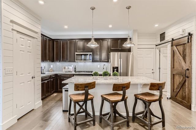 a kitchen with stainless steel appliances kitchen island a refrigerator and a stove top oven