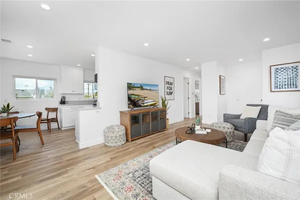 a living room with furniture a flat screen tv and kitchen view