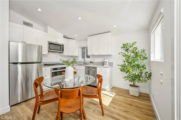 a kitchen with granite countertop white cabinets and stainless steel appliances