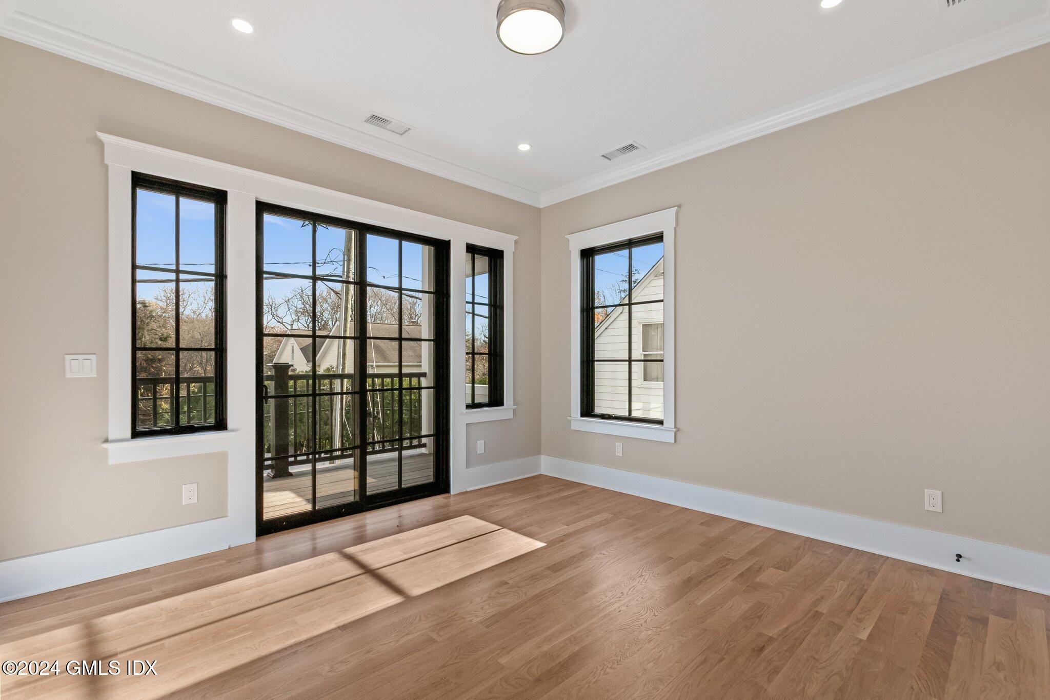 96 Weaver Street, Unit A Greenwich, CT 06831 - Photo 13 of 26 a view of an empty room with a window and wooden floor