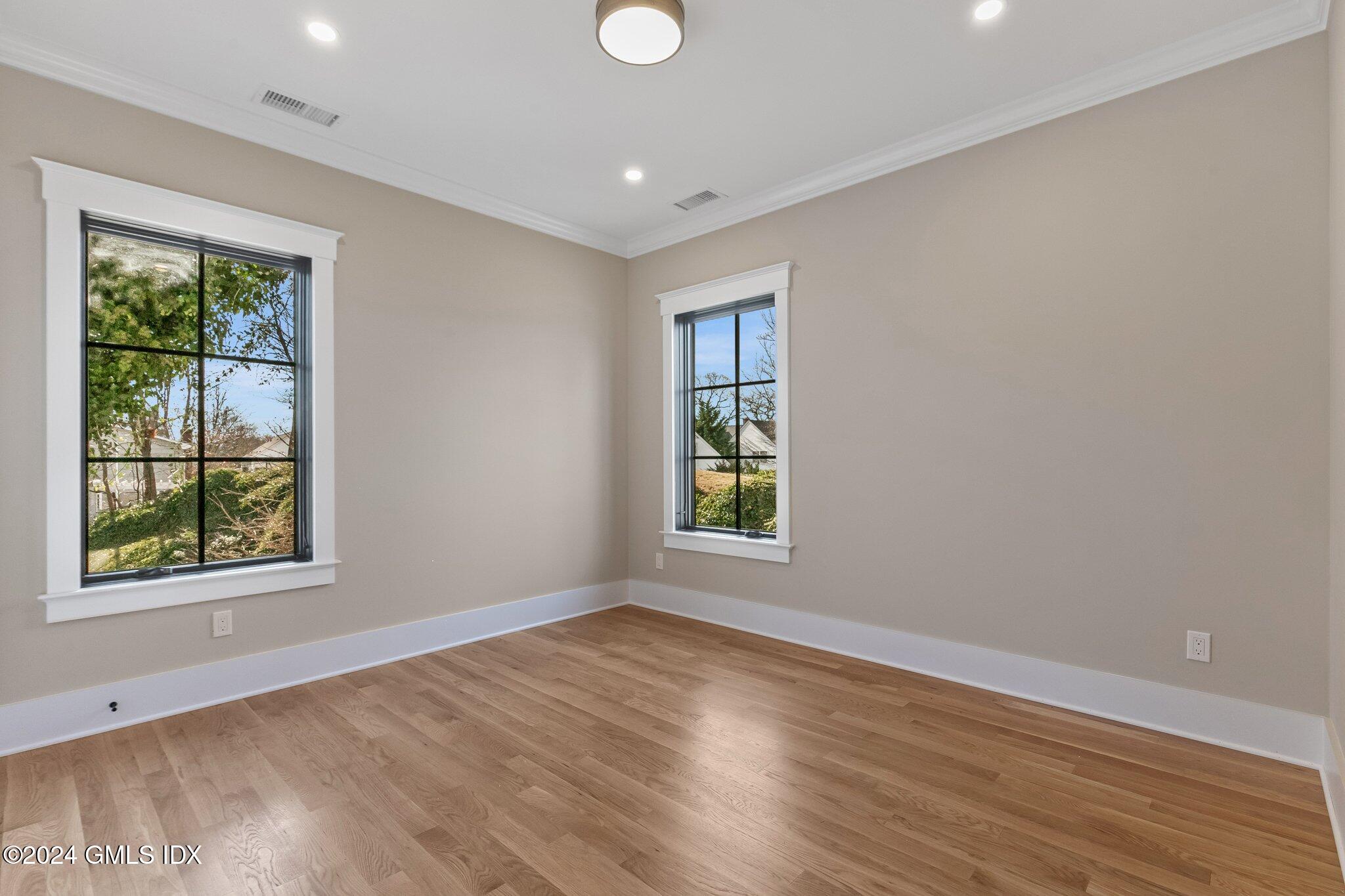 96 Weaver Street, Unit A Greenwich, CT 06831 - Photo 17 of 26 an empty room with wooden floor and windows
