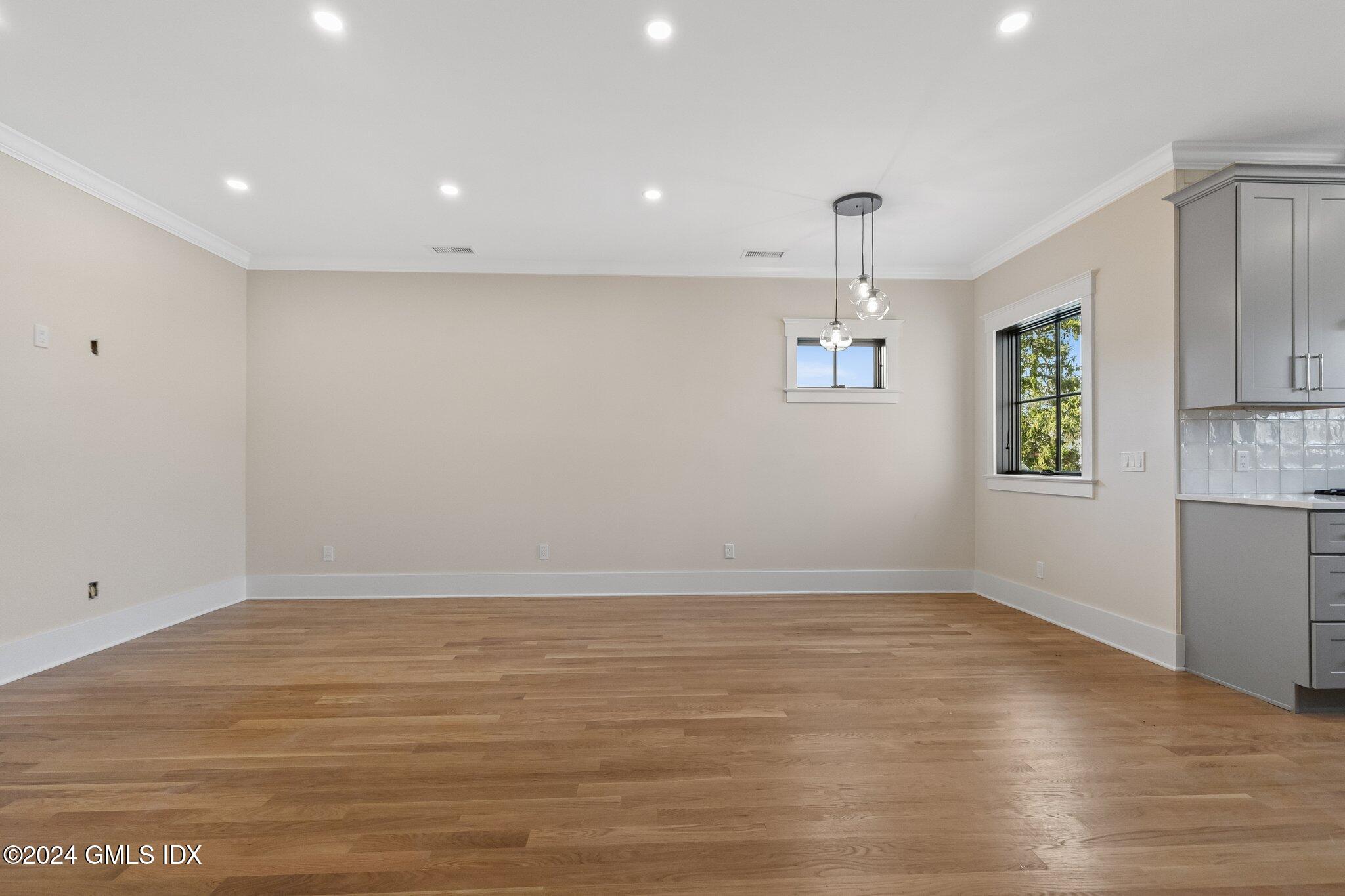 96 Weaver Street, Unit A Greenwich, CT 06831 - Photo 6 of 26 an empty room with wooden floor and windows